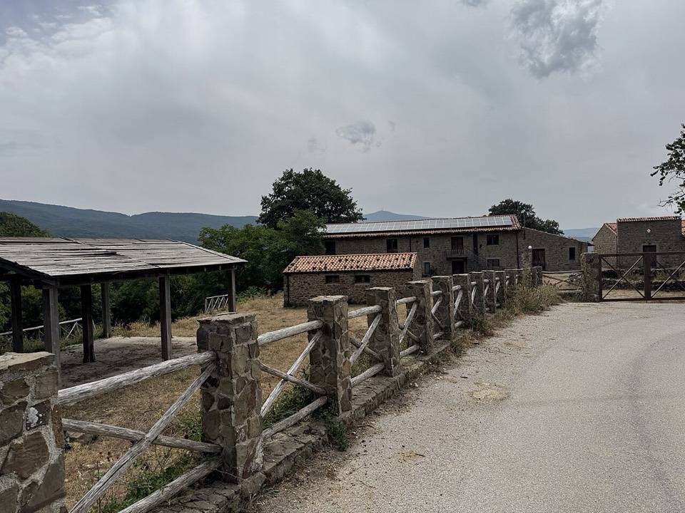La strada che passa davanti a Case Mangalaviti, fra staccionate in pietra e legno