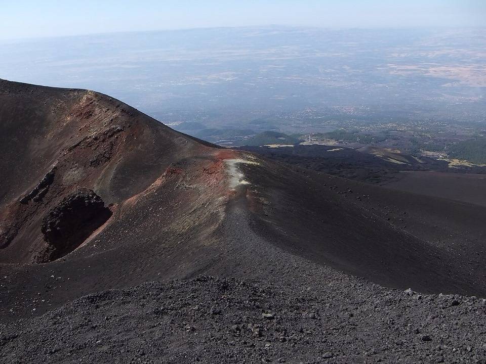 Il bordo di un cratere dell'Etna con la vista sulla pianura e sul mare