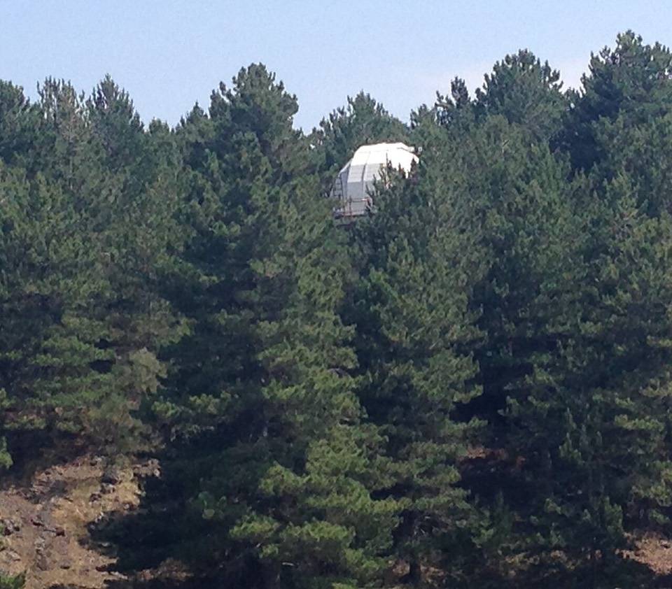 La cupola dell'osservatorio astrofisico di Serra La Nave che spunta fra i pini