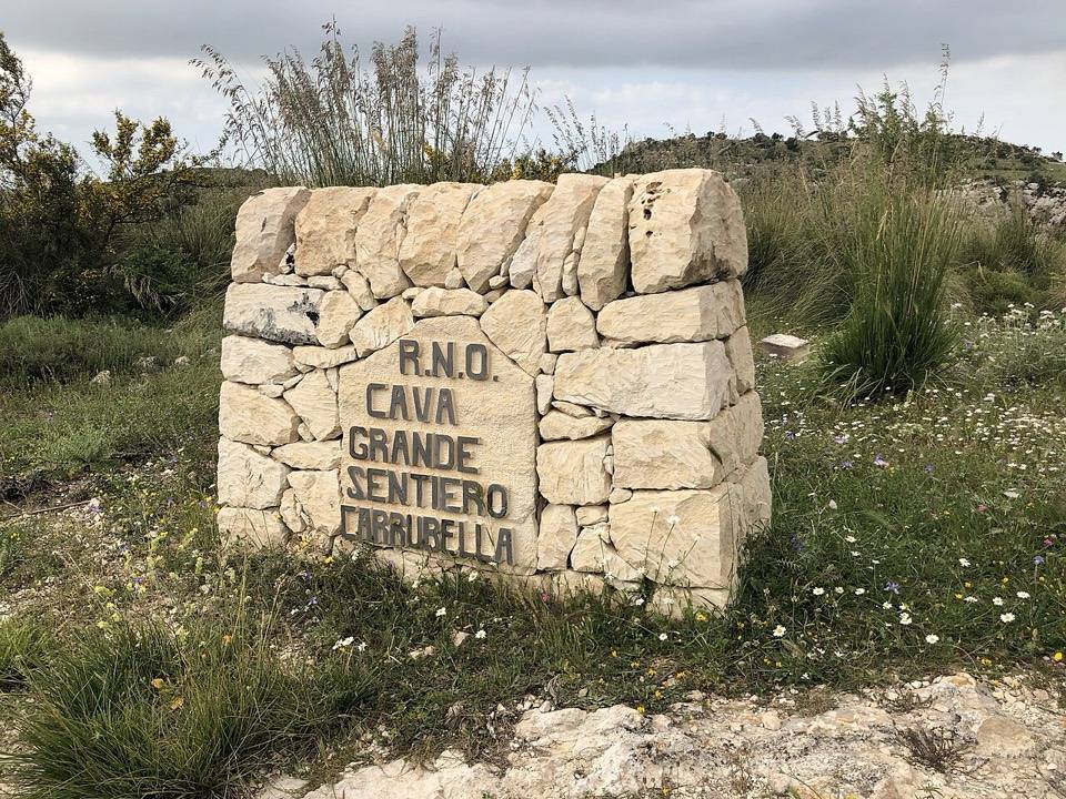 Il cippo in pietra della riserva di Cava Grande all'inizio del sentiero Carrubella