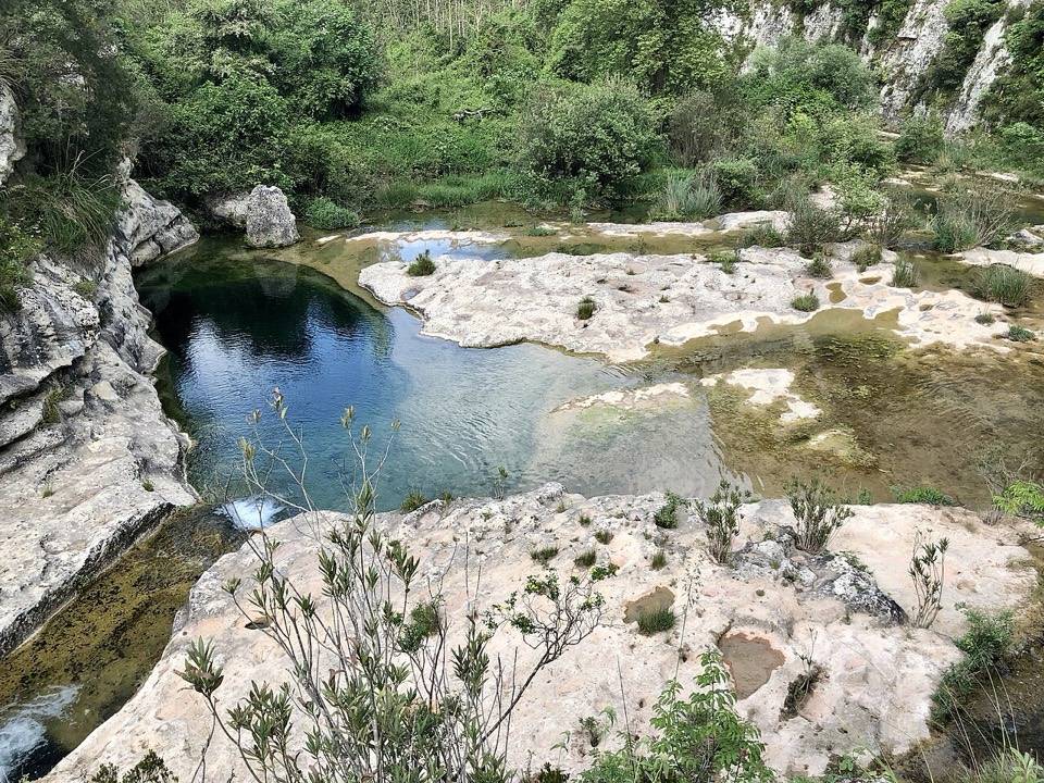 Una delle vasche d'acqua scura dei laghetti di Cavagrande fra le rocce bianche