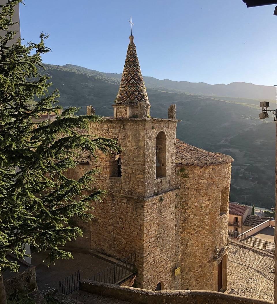 Il campanile di Santo Stefano a Geraci Siculo con i monti delle Madonie alle spalle